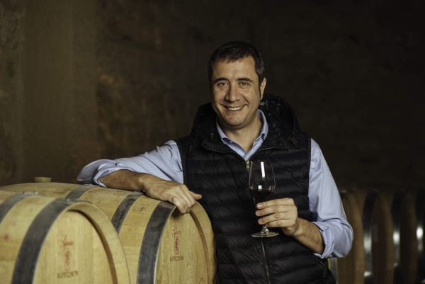 ein lächelnder Mann mit einem Glas Wein in der Hand