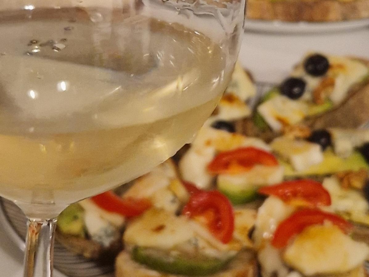 EIn Glas Wein vor einem Teller Tapas