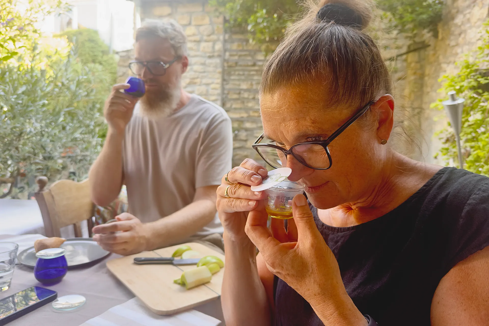 Frau riecht an einem kleinen Behälter mit Olivenöl