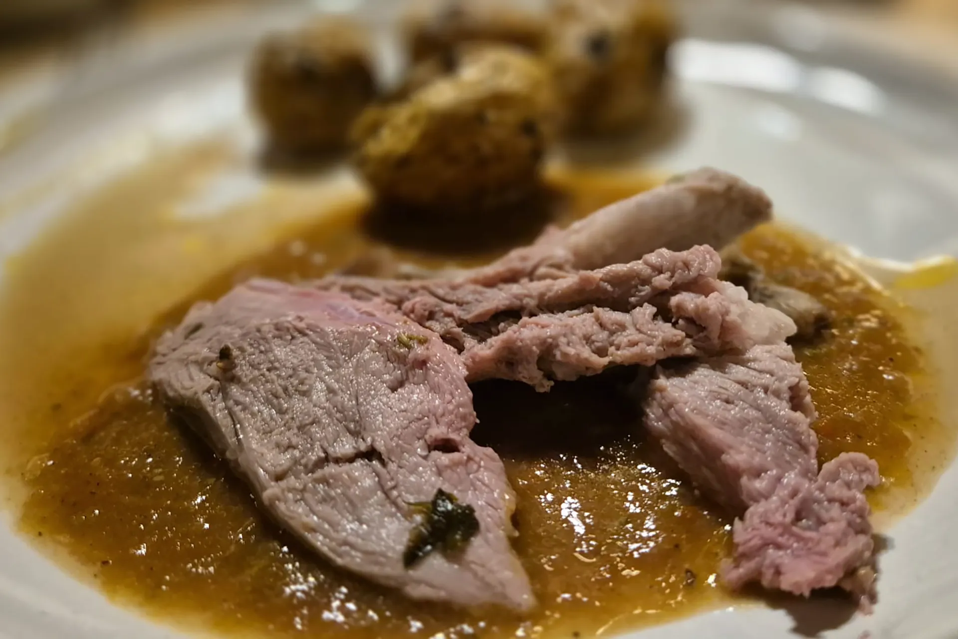 Ein Braten auf einem Teller mit Kartoffeln und Sauce