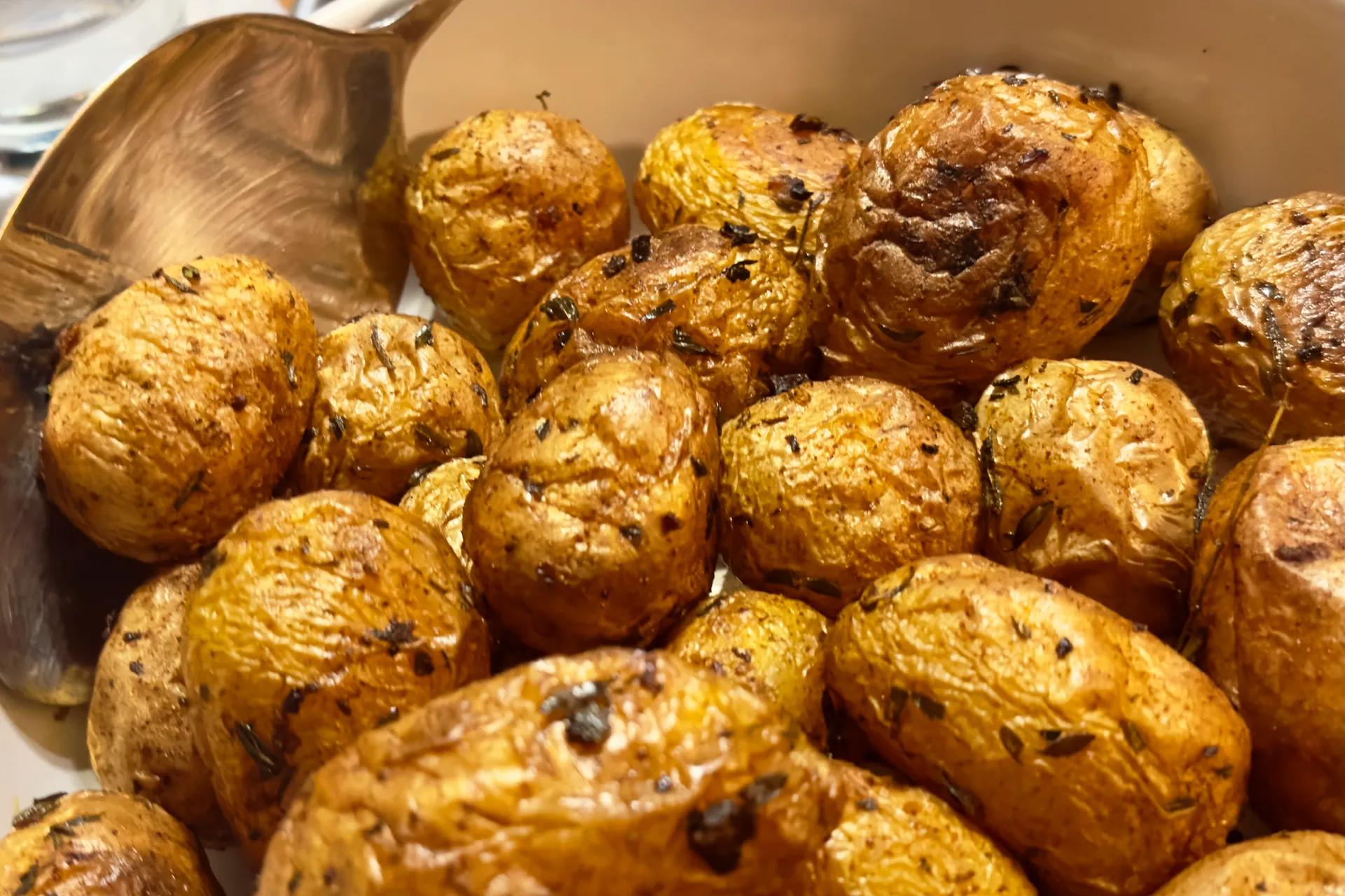 Ofenkartoffeln in einer Schale mit Vorlegebesteck