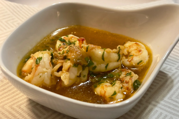 Ein weißes Tonförmchen mit Knoblauchgarnelen