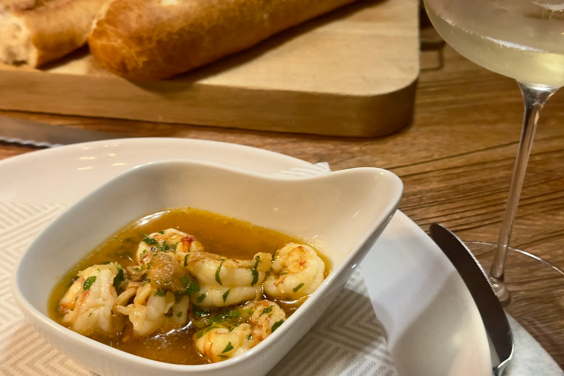 Ein Tisch mit Brot ein Glas Cover und einem Schälchen mit Knoblauchgarnelen