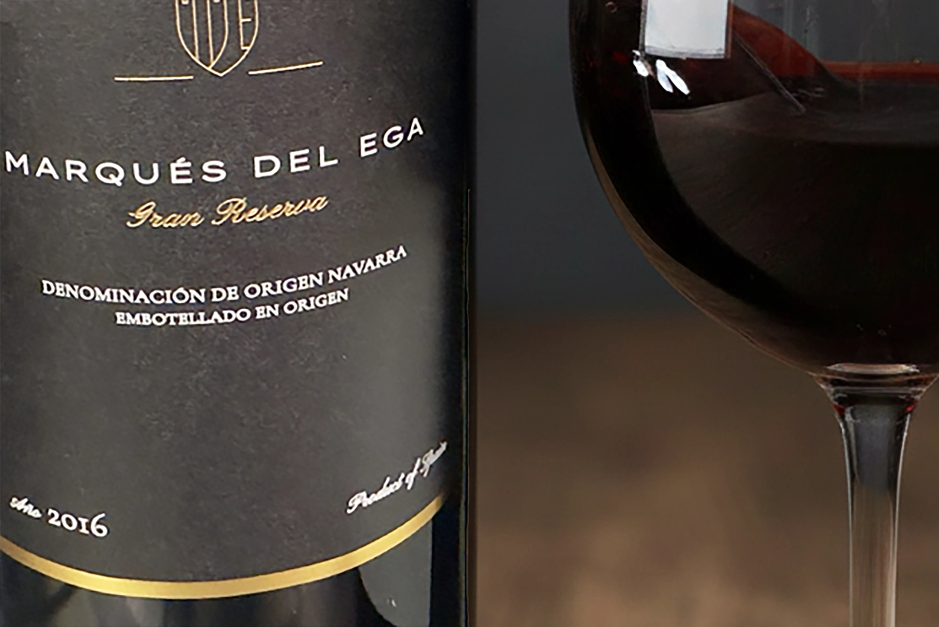 Eine Weinflasche mit angeschnittenem Etikett und einem Glas daneben