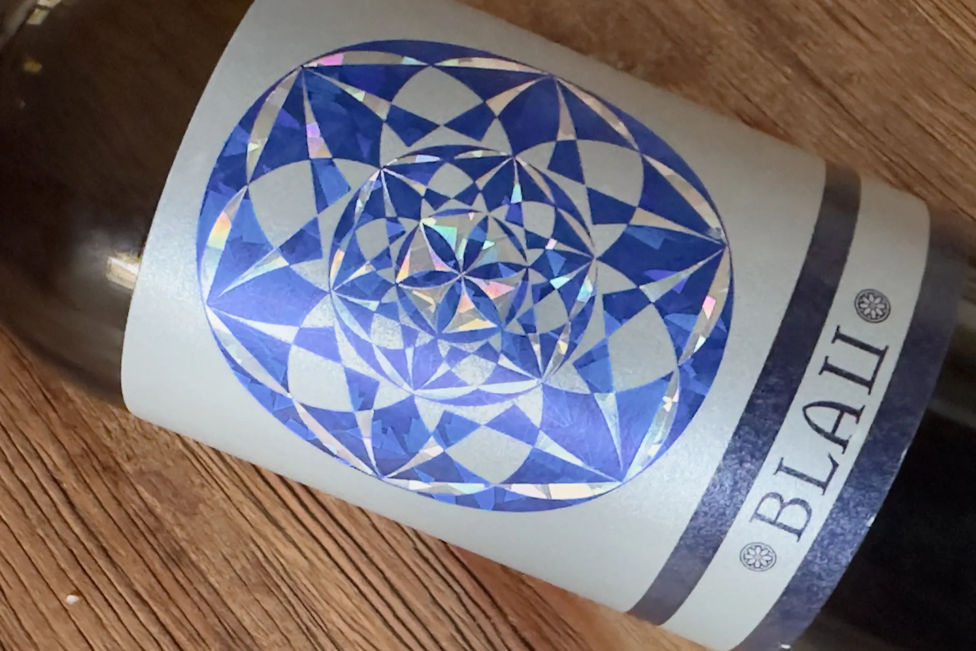 Eine Weinflasche liegt auf einem Holztisch das Etikett von Blau