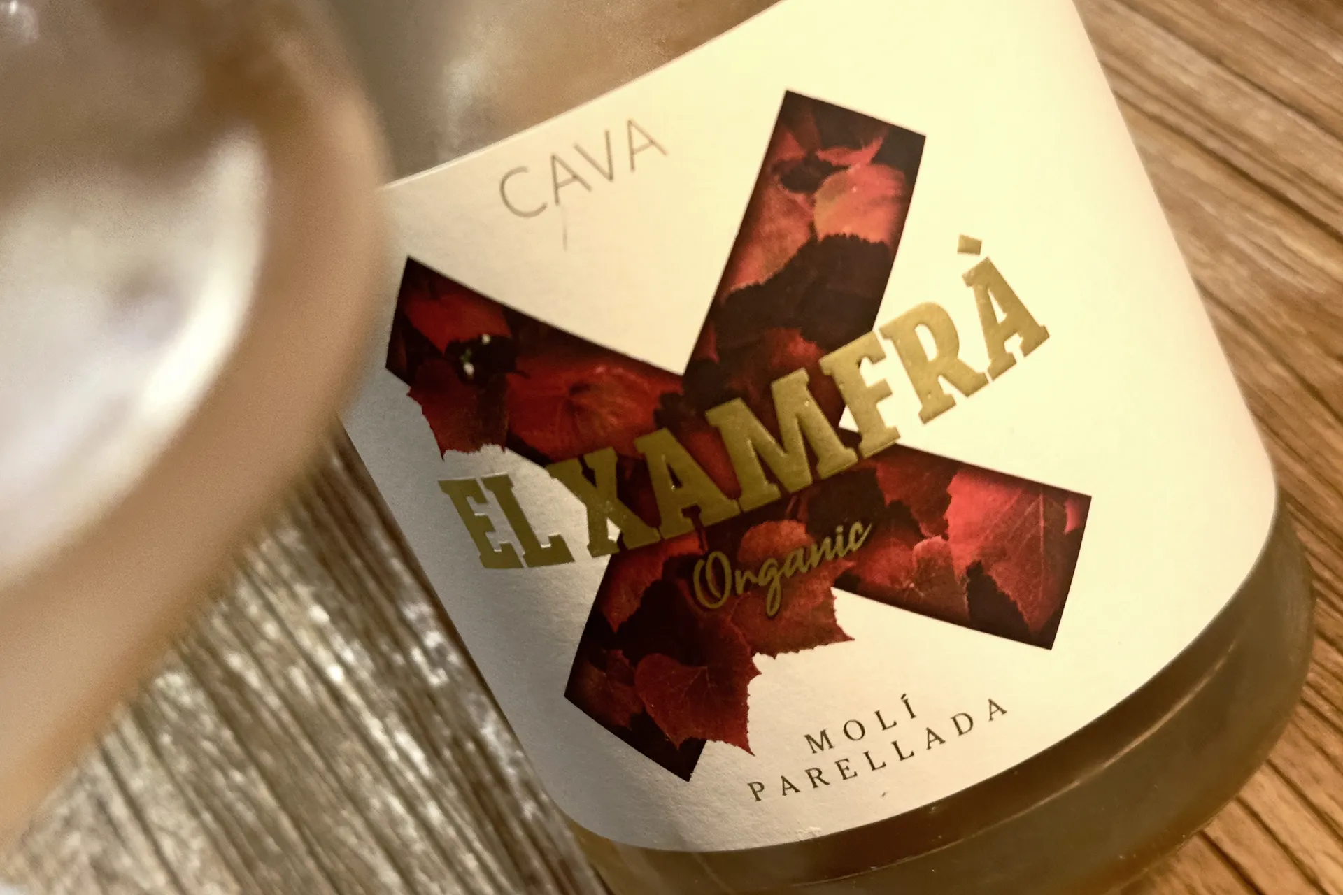 ein Glas mit Schaumwein und das Etikett von EL Xamfra Rose