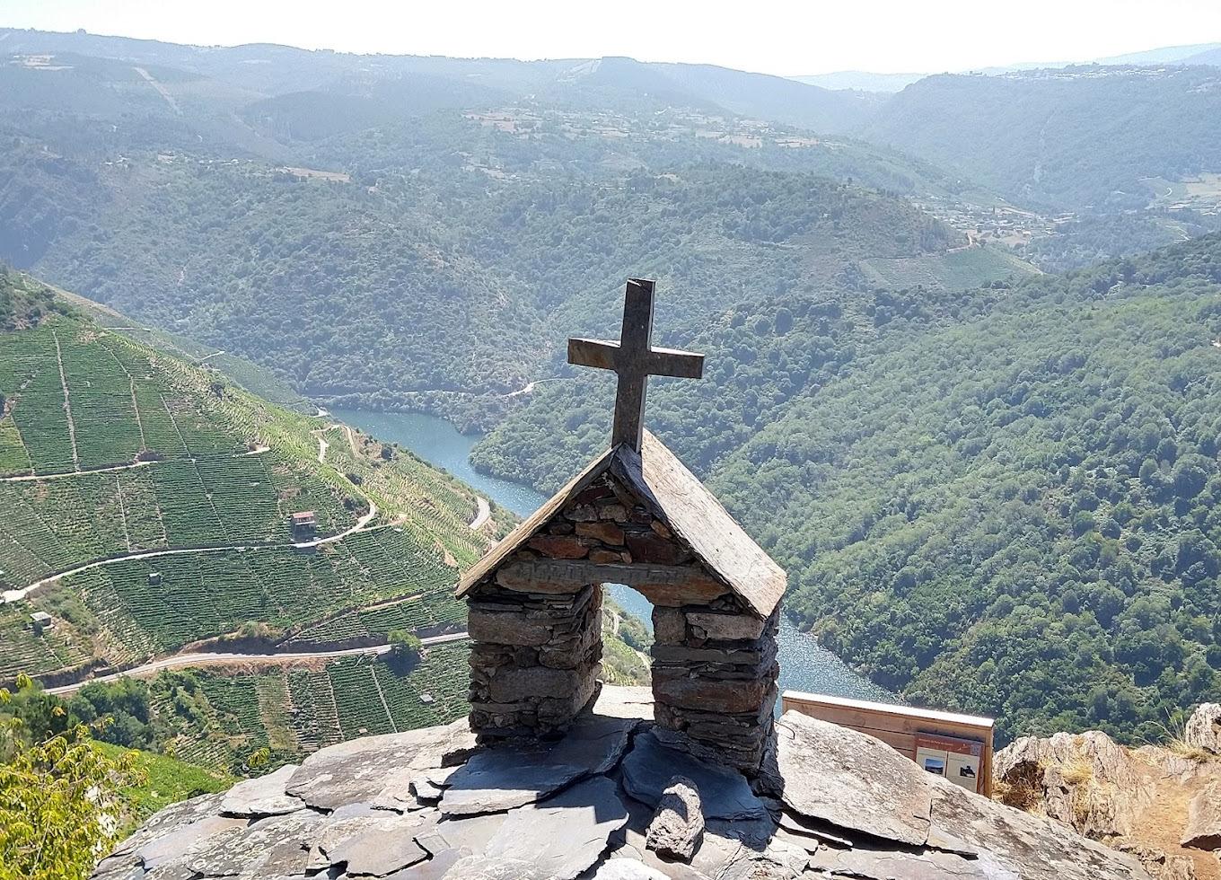 Blick von einer kleinen Kapelle auf einen Hang mit Weinbergen am Fluss
