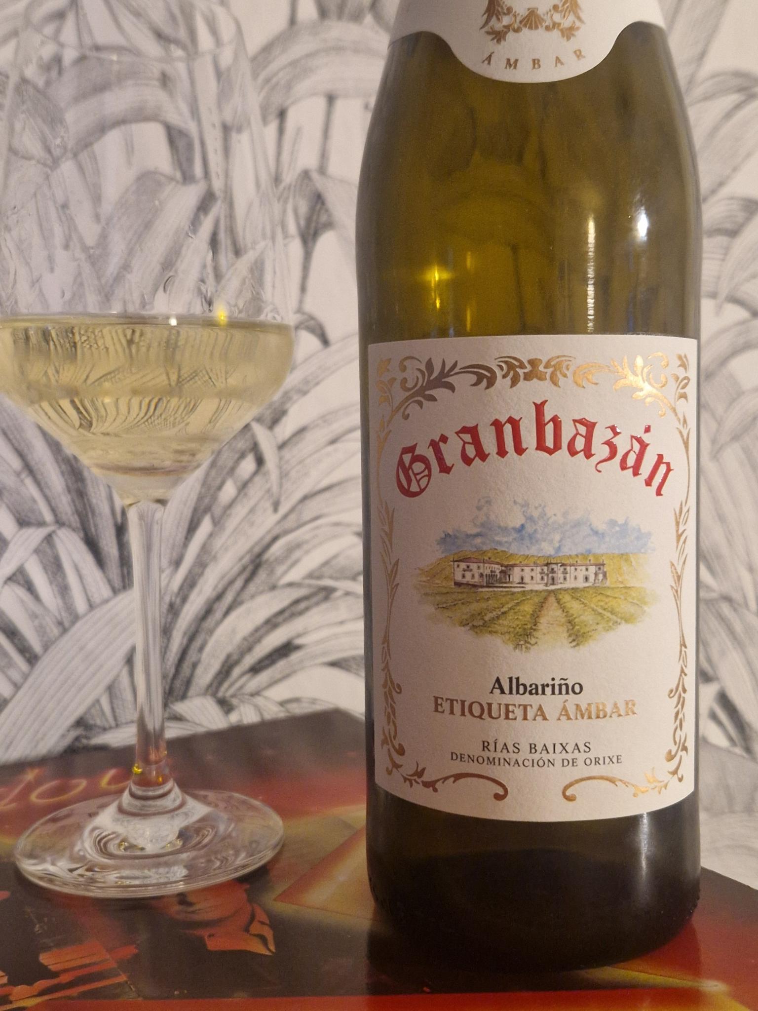 Eine Glas Weißwein neben einer geöffneten Flasche