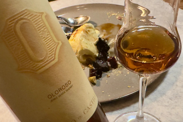 Eine Flasche Sherry mit Glas und Vanilleeis im Hintergrund