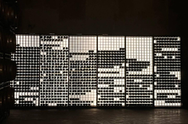 Eine beleuchtete Wand mit Weinflaschen beim Weingut Pago Aylés